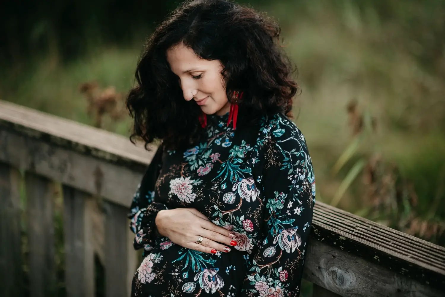 Kobieta w ciąży trzymająca dłonie na brzuchu podczas naturalnej sesji ciążowej w Krakowie